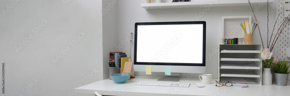 Cropped shot of of simple office desk with blank screen computer on white table Cropped shot of of simple office desk with blank screen computer on white table