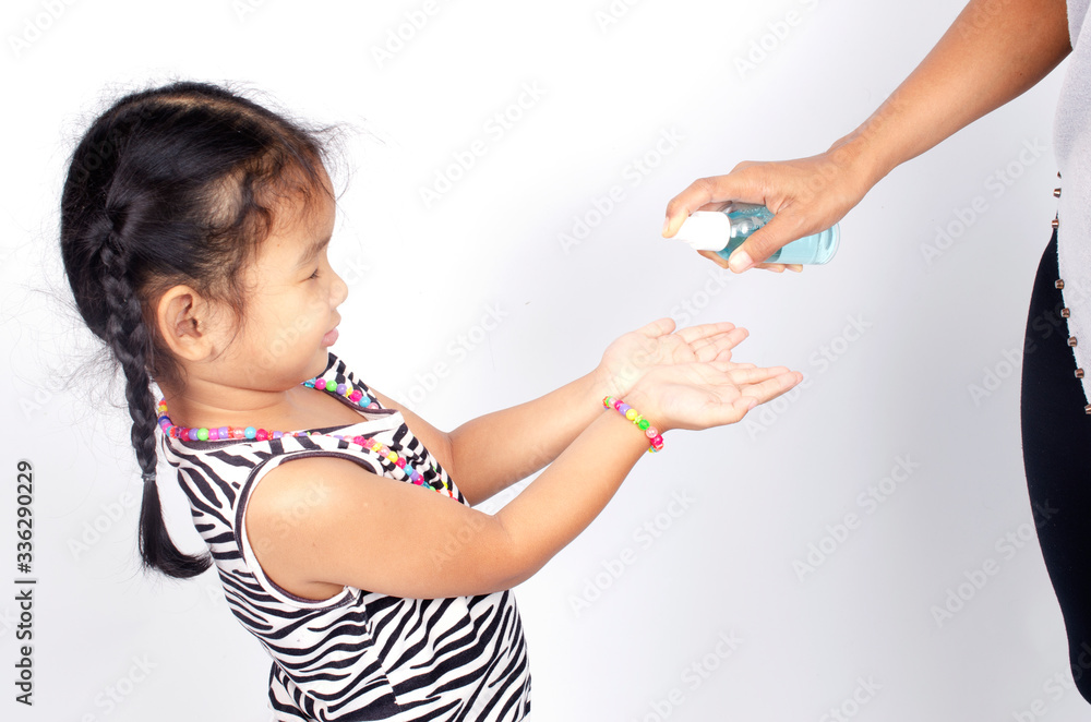 Asian girl kids recived Mother spray hands cleaning with Alcohol sanitize solution for Covid-19 backgrounds Asian girl kids recived Mother spray hands cleaning with Alcohol sanitize solution for Covid-19 backgrounds