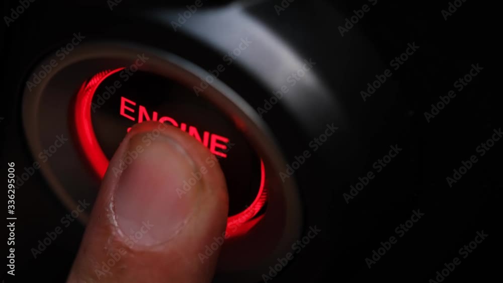 The driver's hand is pressing the car start button. Concept of transportation and technology