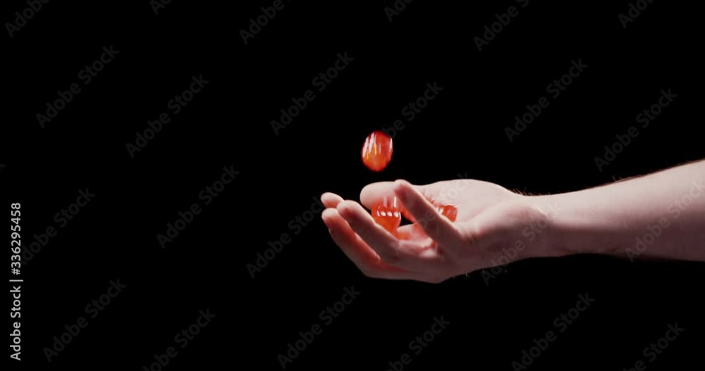 Close up of male hand throwing and chatching red dice with black ...