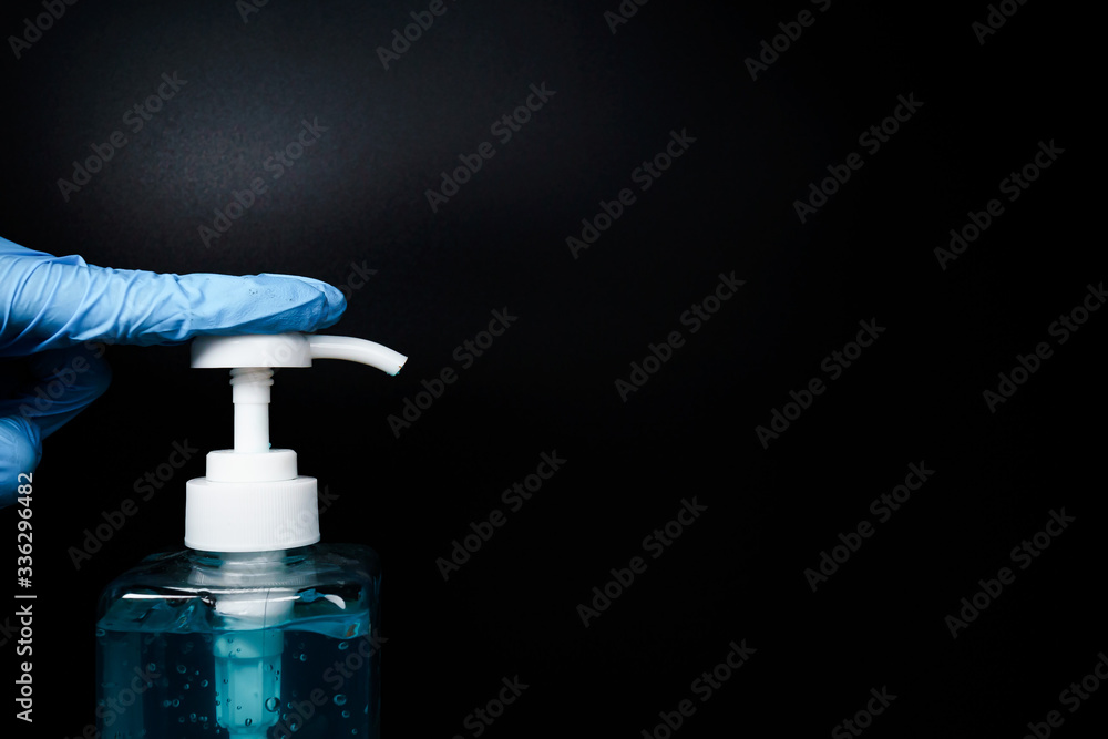 Surgical glove forefinger press the hand sanitizer isolated black background with medium close up shot Surgical glove forefinger press the hand sanitizer isolated black background with medium close up shot
