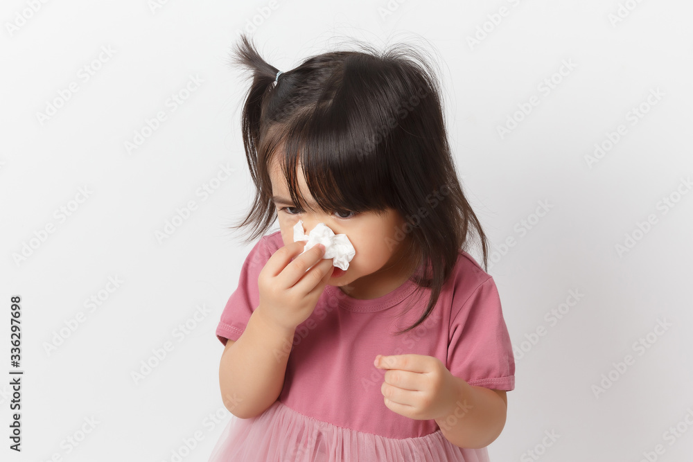 Little asian girl holding a tissue and blow her nose. Kid with cold rhinitis. virus and infection. Coronavirus symptom Little asian girl holding a tissue and blow her nose. Kid with cold rhinitis. virus and infection. Coronavirus symptom