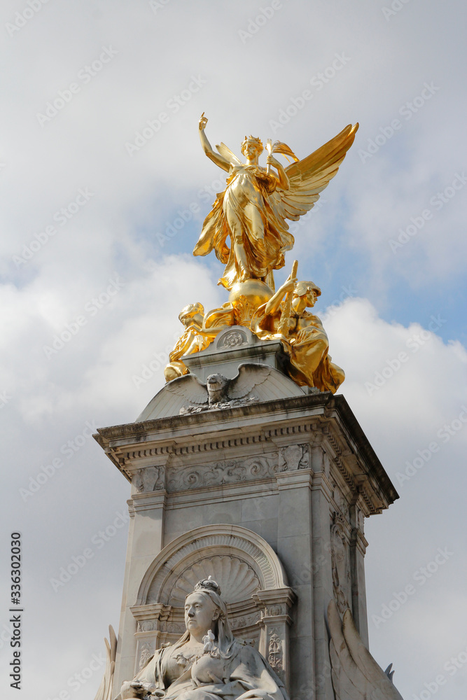 Gilded Winged Victory at the top of the Victoria Memorial in front of Buckingham Palace in a sunny day, London, UK