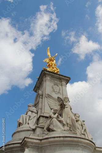 Gilded Winged Victory at the top of the Victoria Memorial in front of Buckingham Palace in a sunny day, London, UK