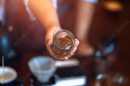 Barista show coffee beans in drip glass.
