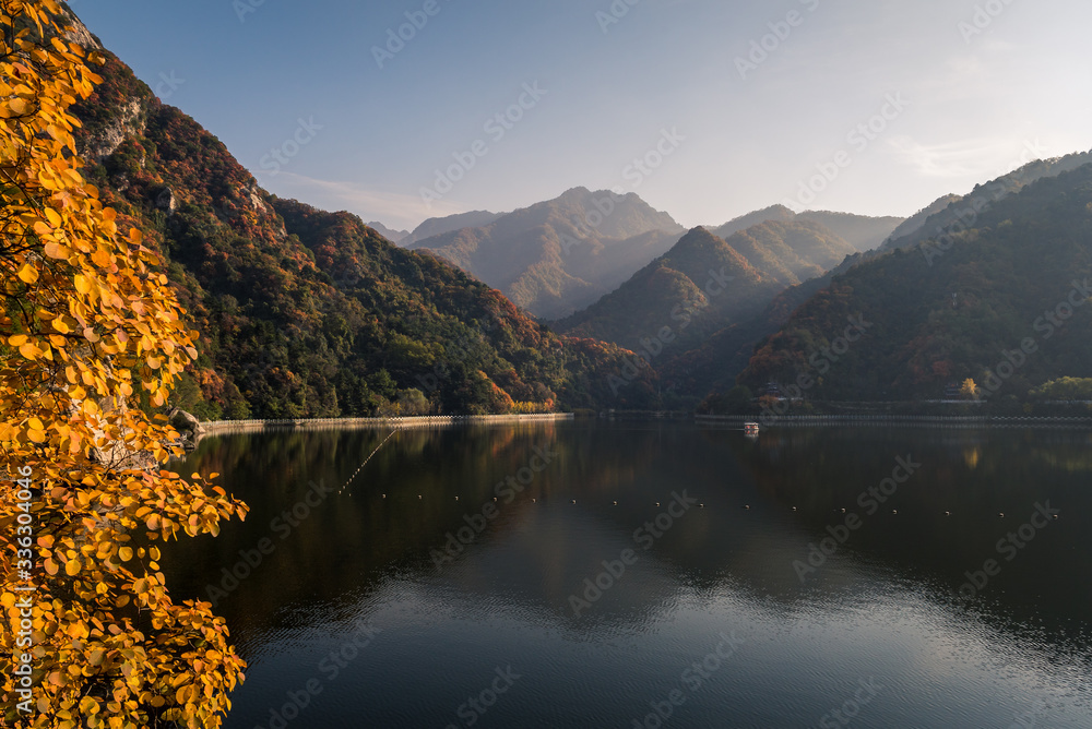 Beautiful clear reflections of a mountain forest with vibrant autumn colors at Cuihua Mountain lake in Xian, China