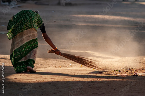 old Indian lady sweeping streets