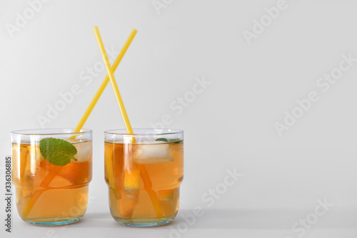 Glasses of tasty cold ice tea on grey background