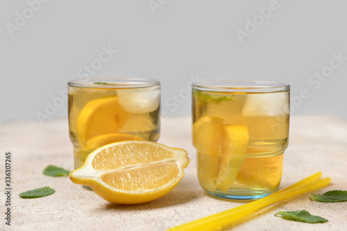 Glasses of tasty cold ice tea on grey background