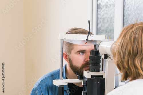 Medicine, health, ophthalmology concept - patient checks her vision by an ophthalmologist.