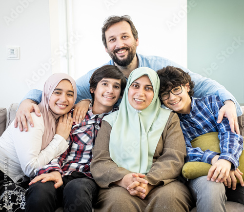 Happy Muslim family portrait on sofa © Jasmin Merdan