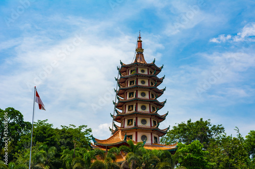 Semarang, Indonesia - CIRCA Nov 2019: Watugong Pagoda in Semarang, Indonesia; in a bright sunny day; with Indonesian flag. This pagoda is dedicated to Avalokitesvara (Guan Yin).