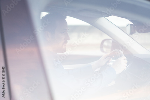 Young and rich male driver in car photo