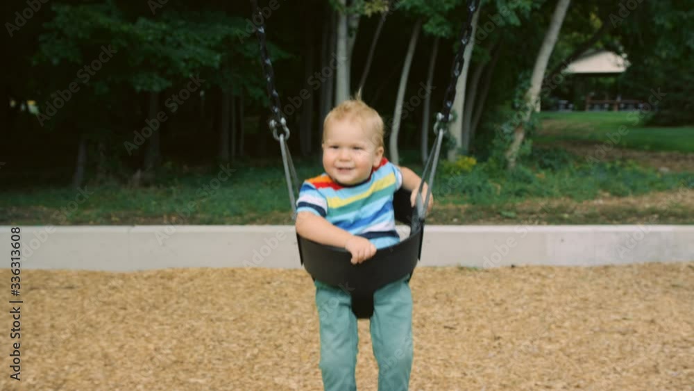 Excited 1 year old toddler boy swings toward camera with big smile slow motion Excited 1 year old toddler boy swings toward camera with big smile slow motion