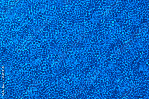 Abstract blue background. Regular texture of water. The shape of the hlad on the water.