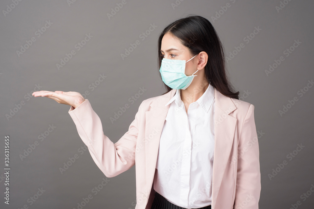 Business woman with mask is showing something on her hand Business woman with mask is showing something on her hand