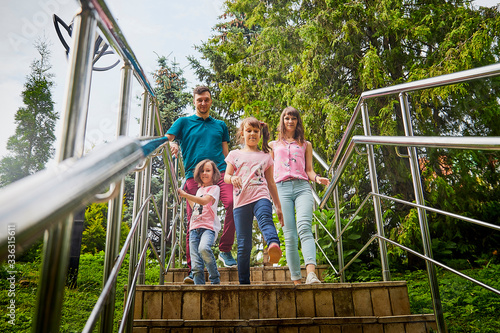 Family of four including father, mother and daughters in the Park on a summer day