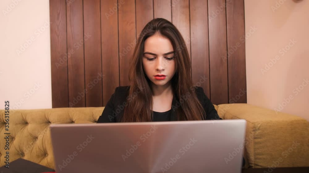Pretty girl sitting at a table in a cafe and working Pretty girl sitting at a table in a cafe and working