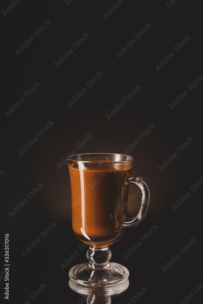 Glass cup with iced coffee on dark background