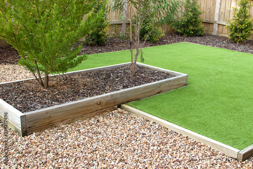 Combination of timber, plants, artificial grass, decorative gravel and mulch photo