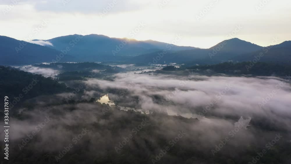 UHD Aerial time lapse view flying over reservoir lake and lush green tropical foggy rain forest with mountain view background. Rolling clouds in early morning sunrise in Kuala Lumpur UHD Aerial time lapse view flying over reservoir lake and lush green tropical foggy rain forest with mountain view background. Rolling clouds in early morning sunrise in Kuala Lumpur