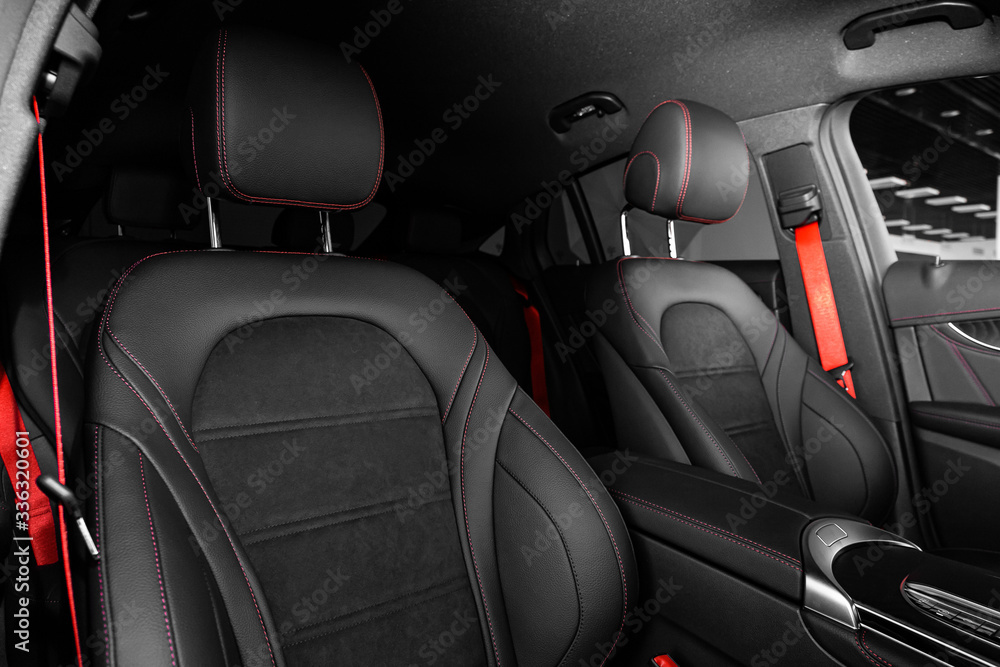 Salon of a new stylish car. Auto interior: driver and passenger seats in black leather.