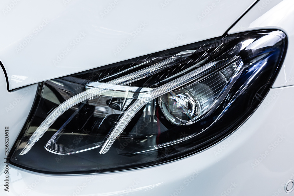 Close up of the car detailing: beauty clean headlights of  white sedan .