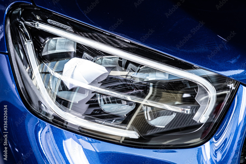 Close up of the car detailing: beauty clean headlights of  blue sedan .