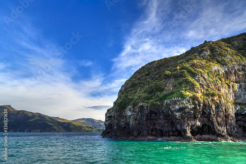 Banks Peninsula on the South Island of New Zealand. A view of the cliffs and sea caves at the entrance to Akaroa Harbour photo