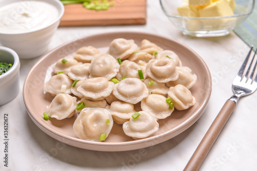 Plate with tasty dumplings on table