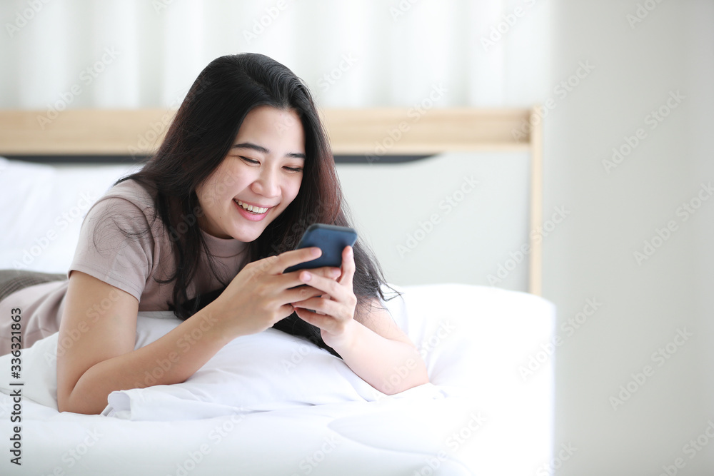 Woman using telephone on bed in bedroom. Woman using telephone on bed in bedroom.