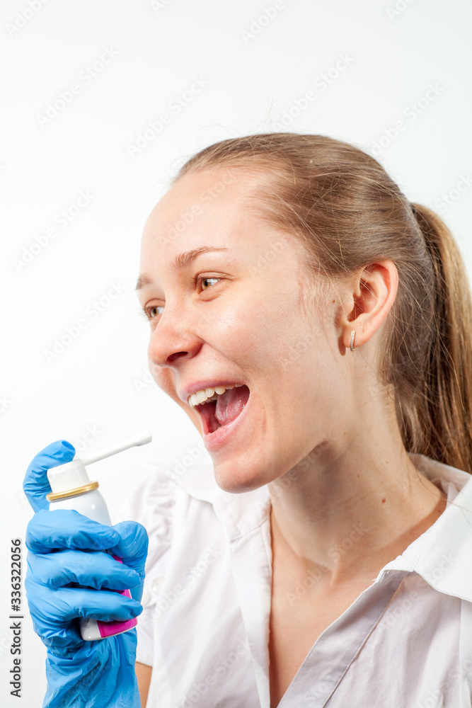 Young doctor uses healing spray to relieve sore throat with sore throat and flu. COVID-19 Young doctor uses healing spray to relieve sore throat with sore throat and flu. COVID-19
