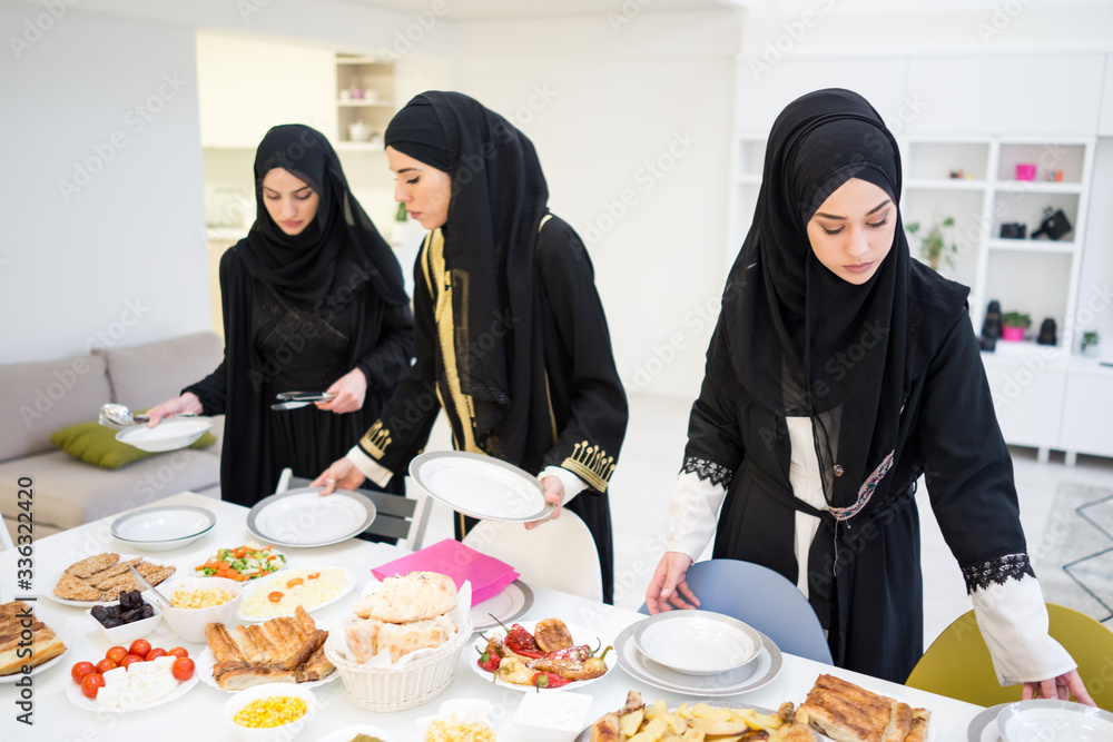 Muslim girls preparing table for family meal Muslim girls preparing table for family meal