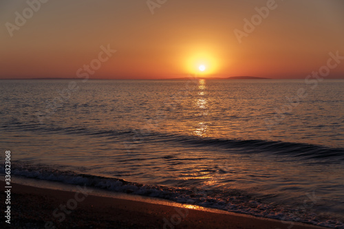 Sea coast at sunset, with the sun, wave, orange sky © Viktoria
