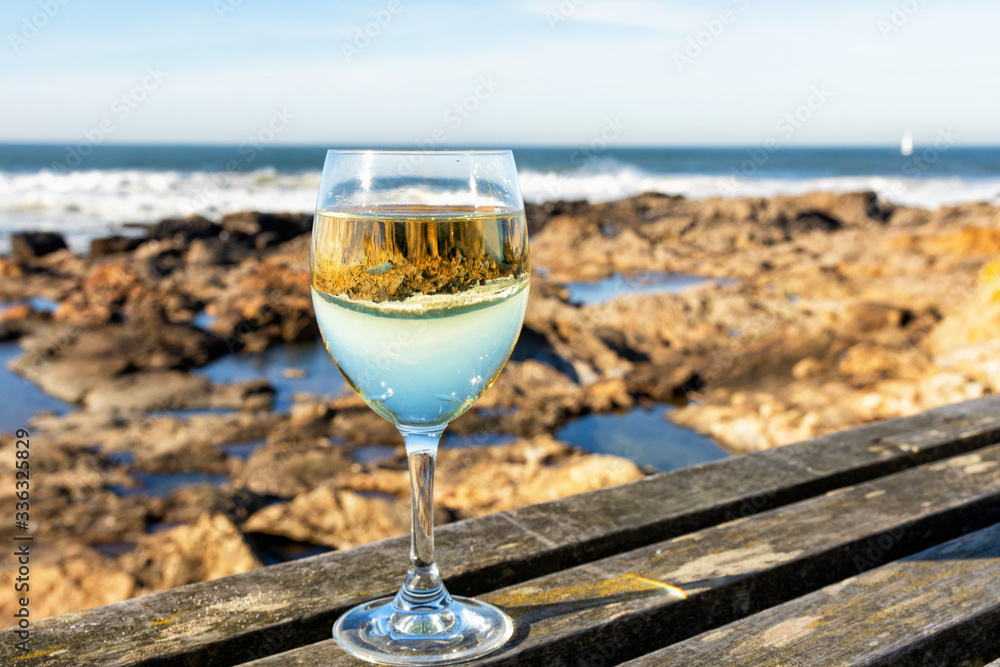 Glass of white wine on the background of the Atlantic Ocean