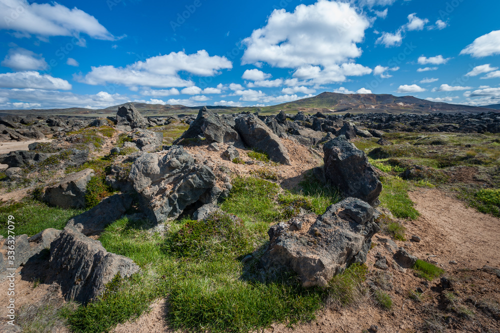 Beautiful colourful Icelandic landscape lava fields mountain geysers zigzag road and moss-covered stones Namafjall, Iceland.