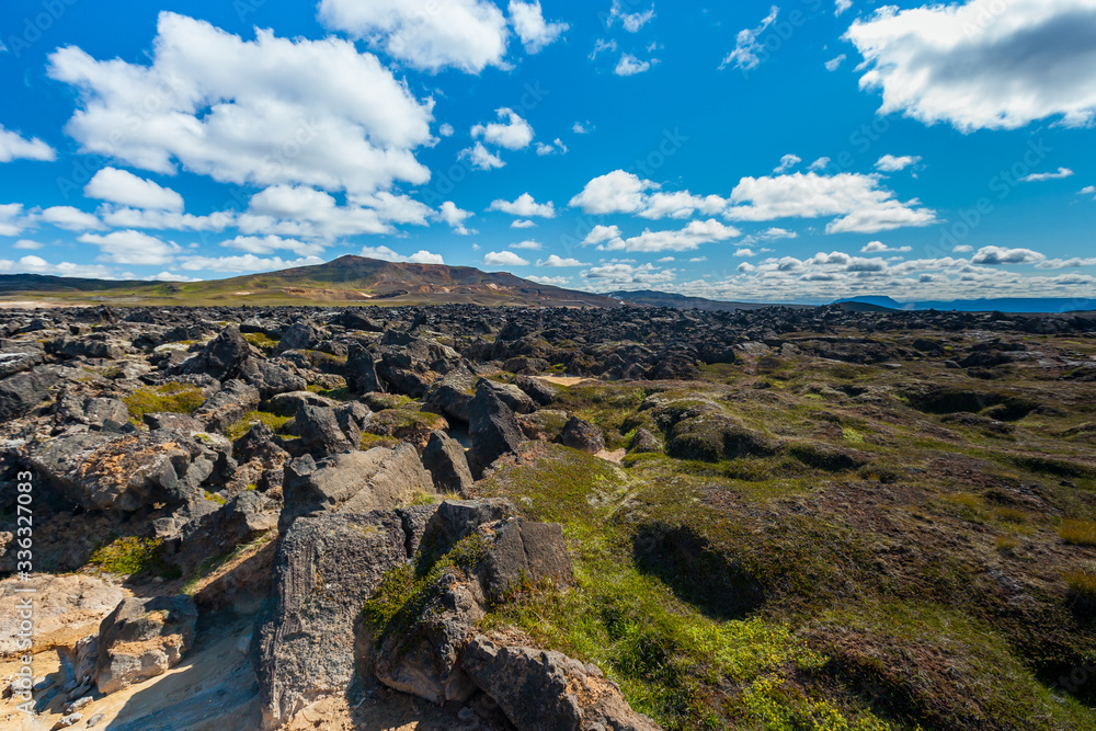 Beautiful colourful Icelandic landscape lava fields mountain geysers zigzag road and moss-covered stones Namafjall, Iceland.