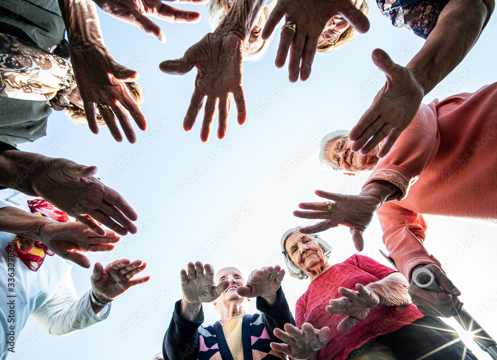 Obraz premium Mature people in circle with hands for unity and friendship