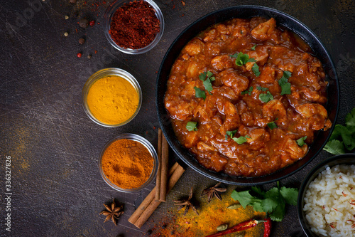 chicken curry with spices on a dark background
