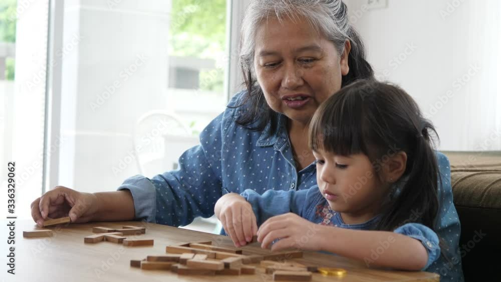 Grandmother and granddaughter stack play in a blocks game, Family relax time and holiday Grandmother and granddaughter stack play in a blocks game, Family relax time and holiday