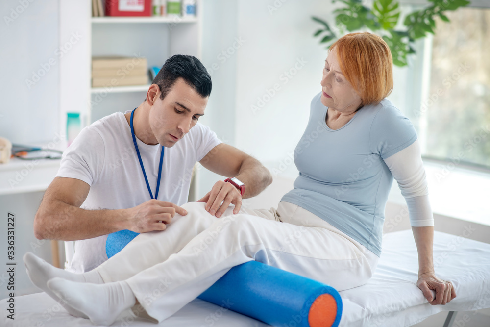 Obraz premium Pleasant senior woman having her legs treated