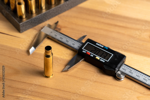 Production of cartridges for a rifle, reload. Measurement of the empty cartridges with a caliper. Side view