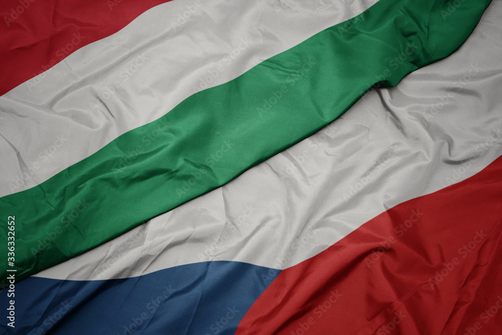 waving colorful flag of czech republic and national flag of hungary.
