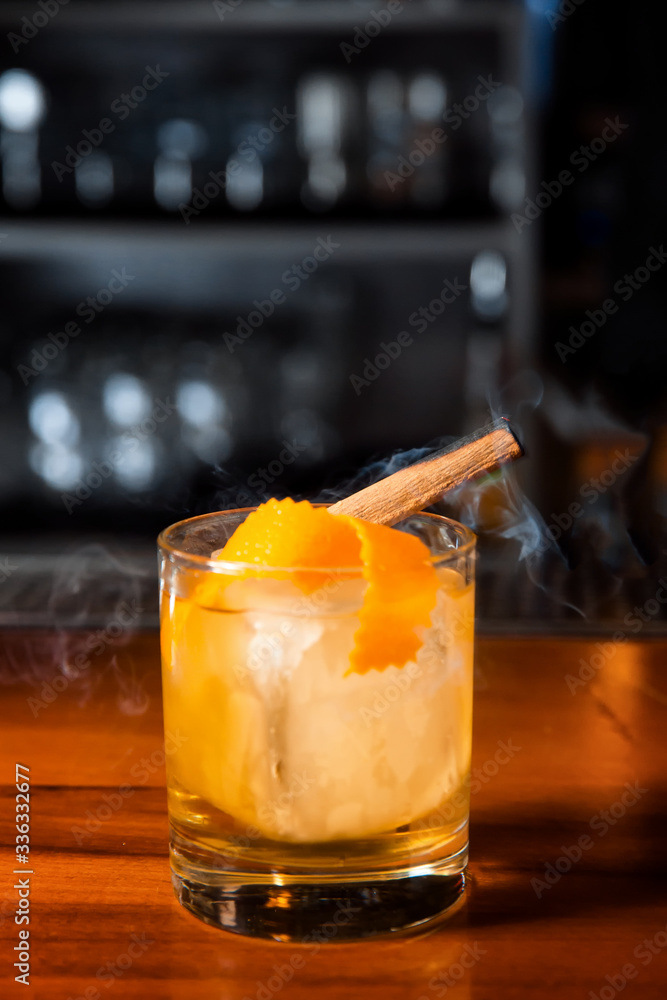 Orange cocktail with ice cube and orange zest. Orange cocktail with ice cube and orange zest.