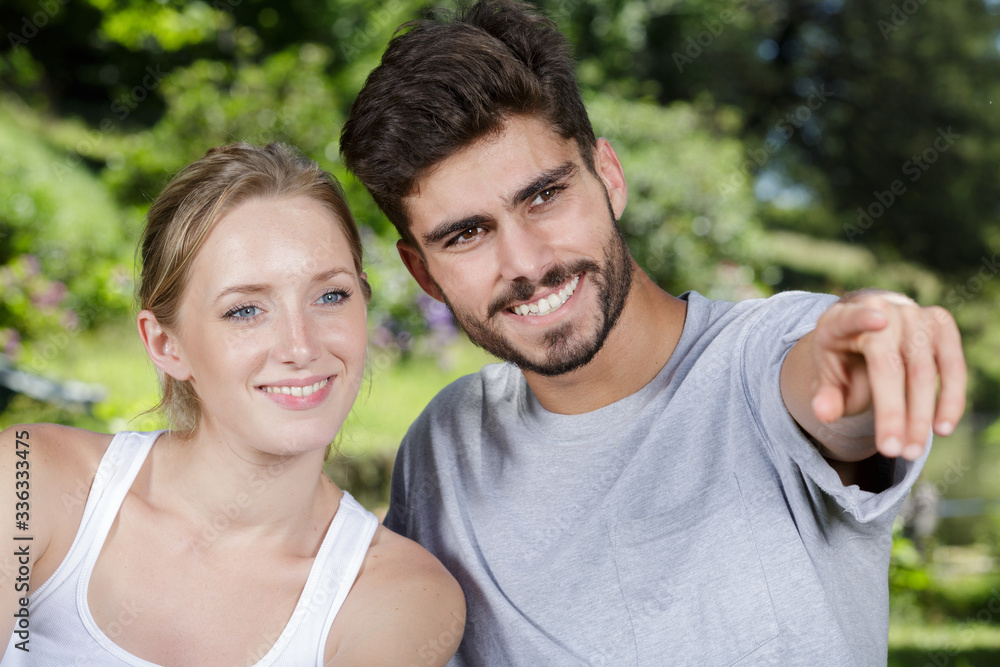smiling couple pointing away on white background smiling couple pointing away on white background