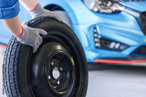 Asian man car inspection Measure quantity Inflated Rubber tires car.Closeup hand holding tire and blue car for tyre pressure measurement for automotive, automobile Car industry image