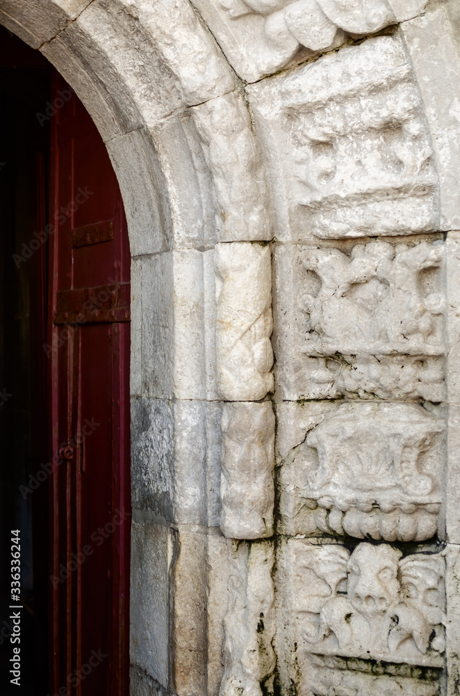 Exterior view and detail of the entrance door of the tower of belem, in Lisbon, Portugal, seen from the outside bridge and decorated with manueline gothic bas relief