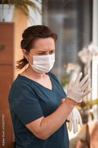 Female surgeon or nurse wearing a sterile suit putting on sterile rubber gloves to perform a surgery, Hand wearing a surgical gloves before starting the operation, Step by step procedures.