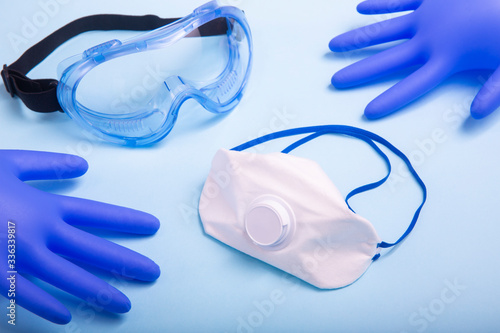 Coronavirus personal protective equipment (PPE) concept. Medical latex gloves, protective goggles and ffp2 respirator.