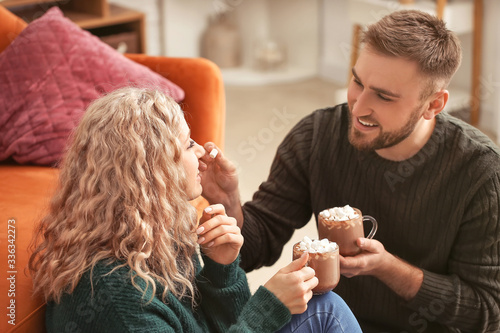 Happy young couple drinking hot cocoa at home